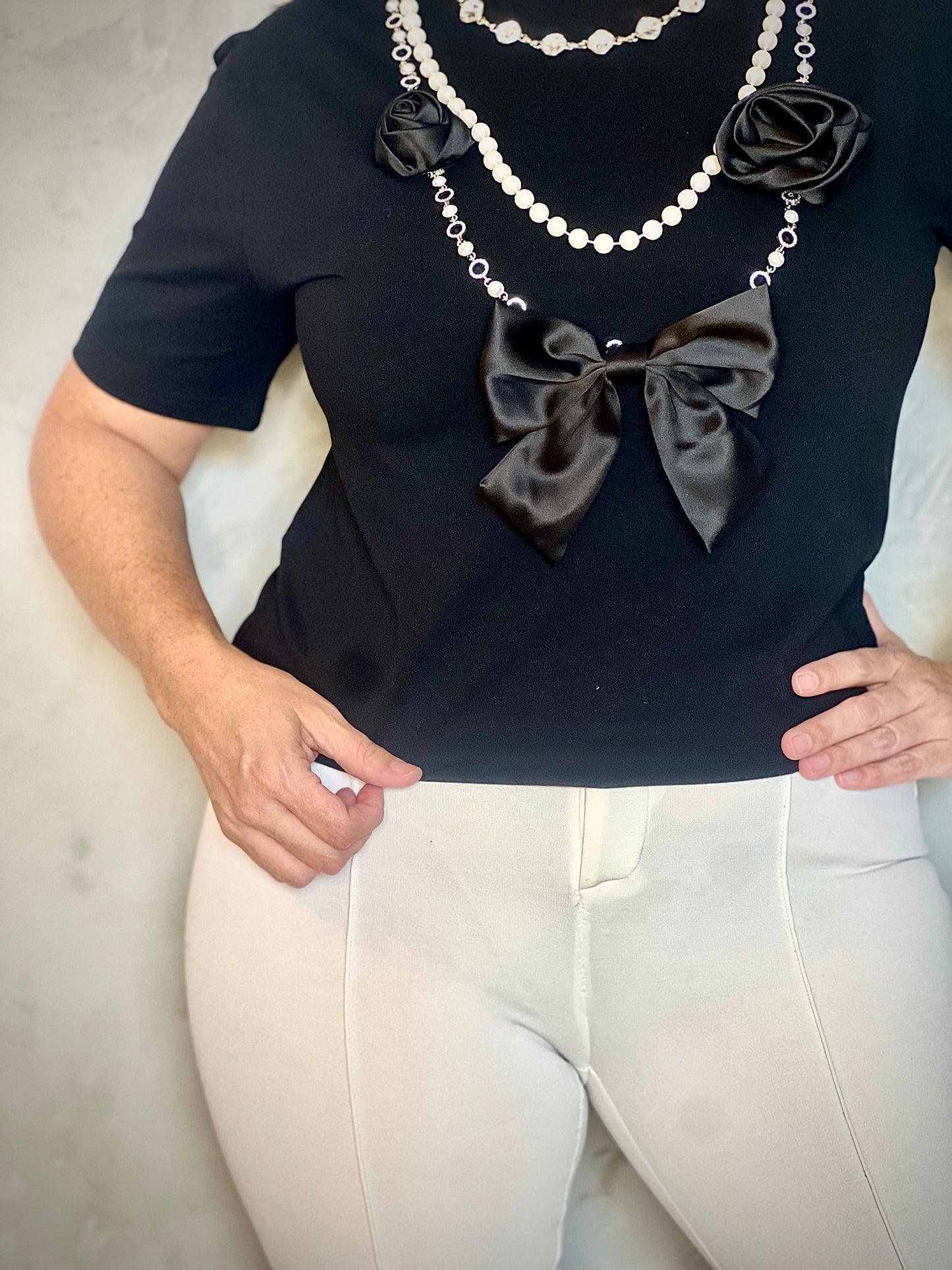 TOP NEGRA CON DETALLES DE LAZO , FLORES Y PERLAS