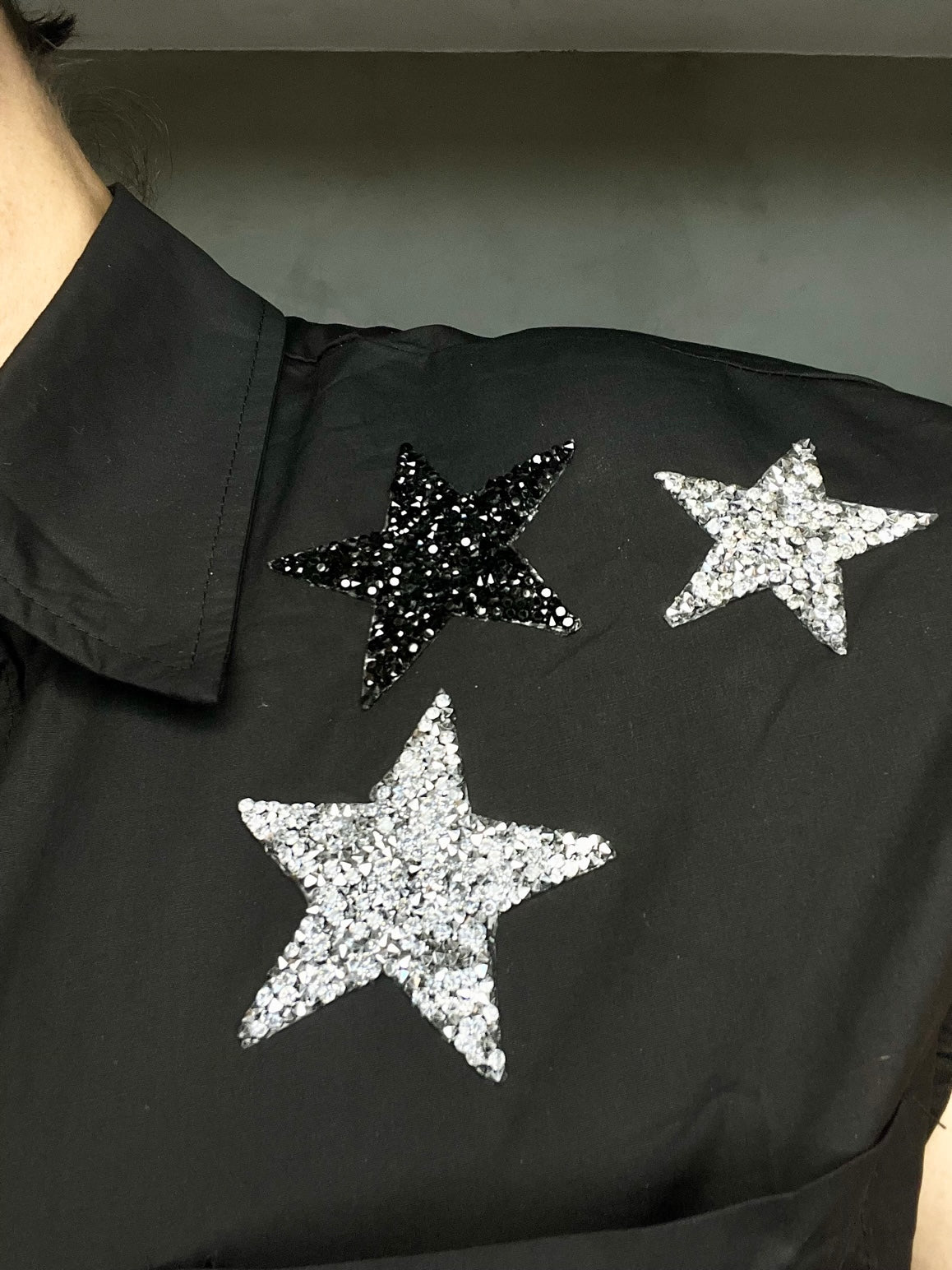 CAMISA NEGRA CON APLICACIONES EN ESTRELLAS